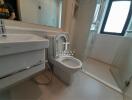 Modern bathroom with white fixtures and a large window