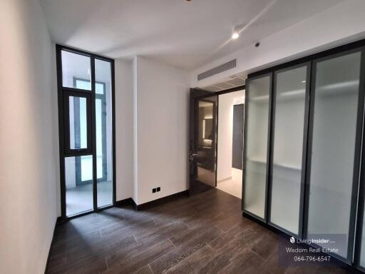 Modern bedroom with large windows and ensuite bathroom