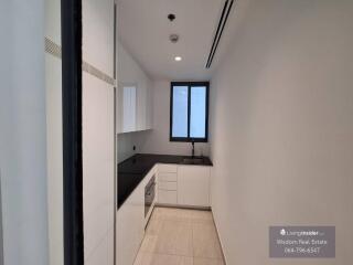 Modern narrow kitchen with white cabinetry and black countertops