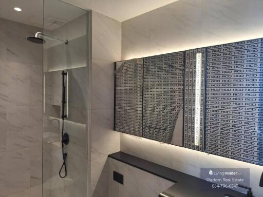 Modern bathroom with marble walls and a glass shower enclosure