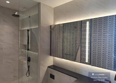 Modern bathroom with marble walls and a glass shower enclosure
