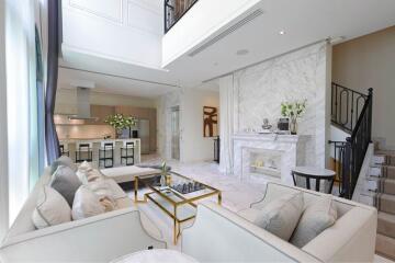 Spacious and modern open plan living room with kitchen, featuring marble accents and stylish furnishings