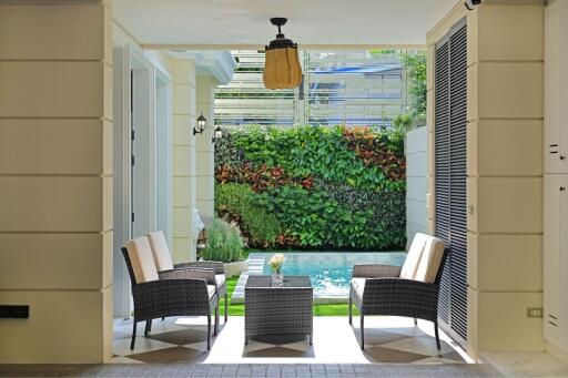 Elegant patio area with wicker chairs facing a vibrant garden wall