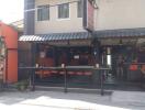 Exterior view of urban commercial bar with seating and awning