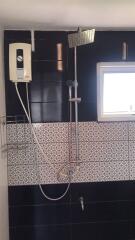 Modern bathroom with wall-mounted shower unit and stylish tiling