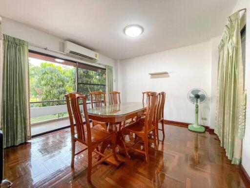 Spacious dining room with wooden furniture and garden view