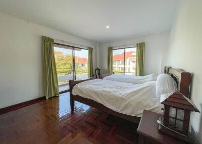 Spacious bedroom with large windows and hardwood floors