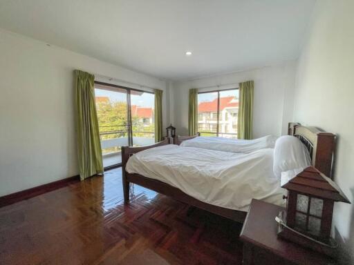 Spacious bedroom with large windows and hardwood floors