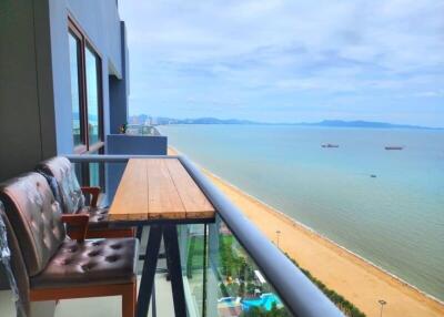 Spacious balcony with a seaside view featuring outdoor seating