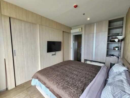 Modern bedroom with wooden wardrobes and wall-mounted TV