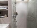 Modern bathroom interior with a glass shower, large tiles, and stylish storage shelves