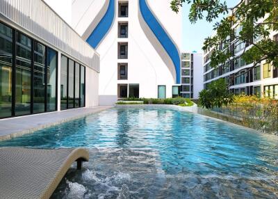 Modern residential building with a luxurious outdoor swimming pool and landscaped areas