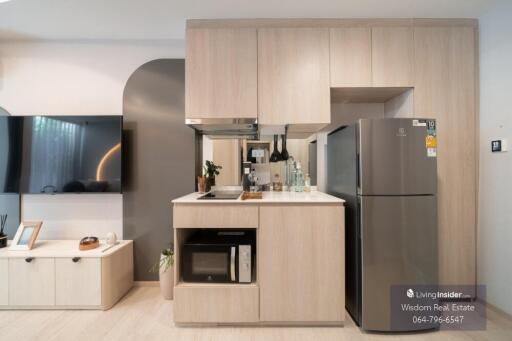 Modern kitchen with light wood cabinets and stainless steel appliances