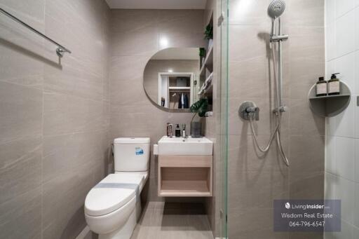 Modern bathroom with wall-mounted toilet, sink, and shower