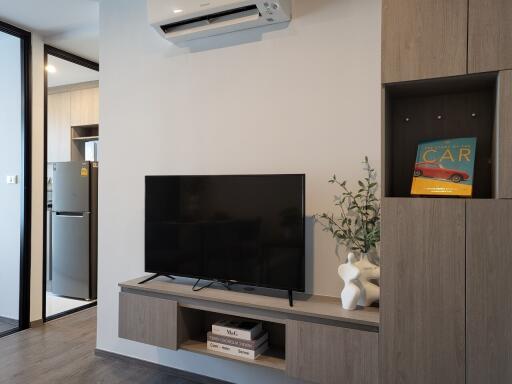 Modern living room with sleek design featuring a wall-mounted TV and wooden storage units