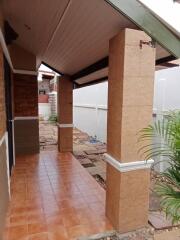 Covered patio area with tiled flooring and brick columns