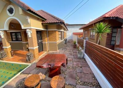 Spacious outdoor patio area with seating and adjacent to residential buildings