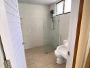 Compact modern bathroom with tiled walls and natural lighting
