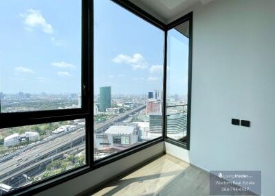Spacious bedroom with large windows offering a panoramic city view