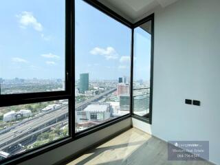 Spacious bedroom with large windows offering a panoramic city view