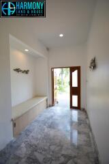 Bright and spacious entryway with marble flooring and wooden door