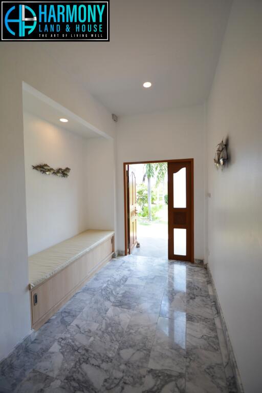 Bright and spacious entryway with marble flooring and wooden door