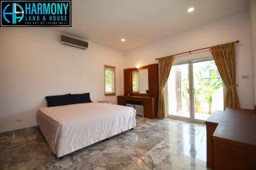 Spacious and well-lit bedroom with large bed and access to a private patio