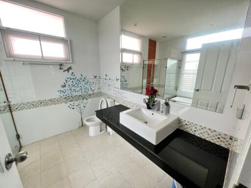 Spacious modern bathroom with decorative tile accents and ample natural light