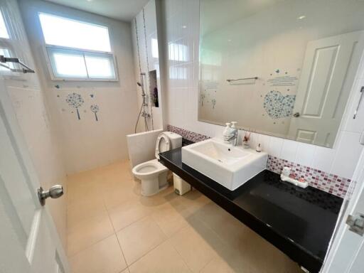 Spacious modern bathroom with large sink and decorated wall tiles