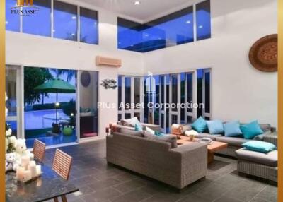 Spacious modern living room with high ceilings and pool view