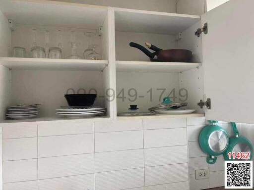 Open kitchen cabinet with dishes and cookware