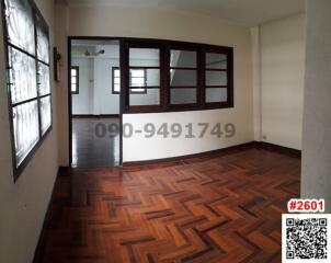 Spacious living room with polished wooden floors and classic white walls