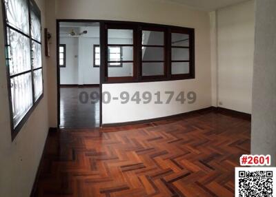 Spacious living room with wooden parquet flooring and large windows