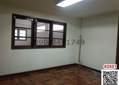 Empty bedroom with parquet flooring and two wooden windows