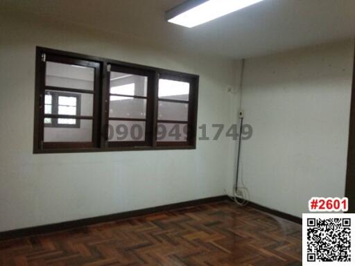 Empty bedroom with parquet flooring and two wooden windows