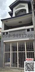 Modern gray two-story residential building with decorative metal gate