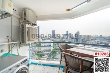 Spacious balcony with city view, washing machine, and outdoor seating