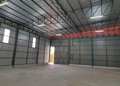 Spacious industrial warehouse interior with metal walls and a large entrance