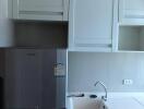 Modern kitchen with white cabinetry and stainless steel refrigerator