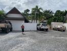 Spacious driveway with multiple vehicles and lush greenery