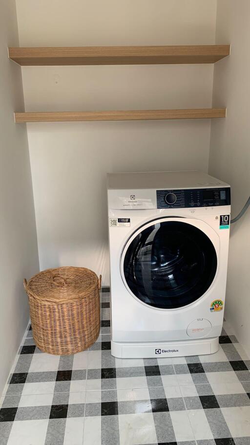 Modern laundry room with washing machine and storage shelves
