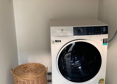 Modern laundry room with washing machine and storage shelves