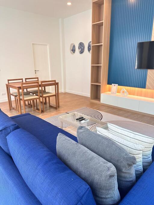 Modern living room with blue sofa and wooden dining set