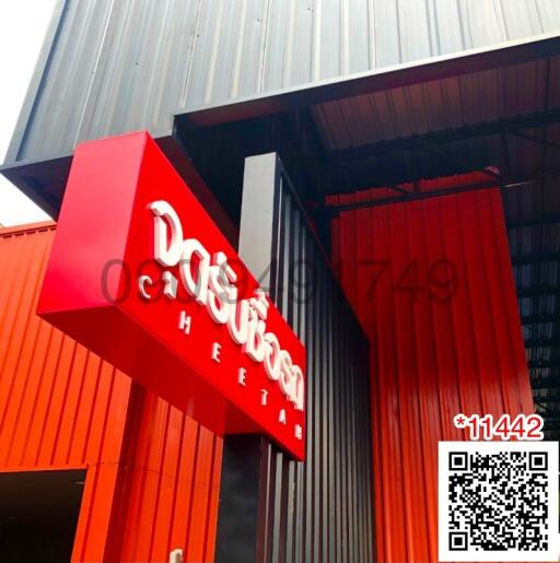 Modern industrial building entrance with red sign and glass doors