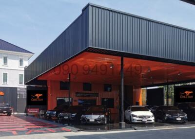 Modern commercial building front with cars and distinctive branding