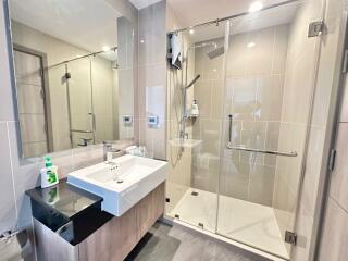 Modern bathroom with glass shower enclosure and ample lighting