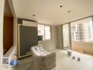 Bright living room with a couch, air conditioner, and large windows leading to a balcony