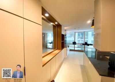 Modern kitchen area with sleek cabinetry and large windows