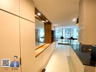 Modern kitchen area with sleek cabinetry and large windows