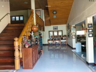 Spacious living room with wooden staircase and traditional decor